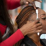 A woman getting her hair done at the best braiding salon
